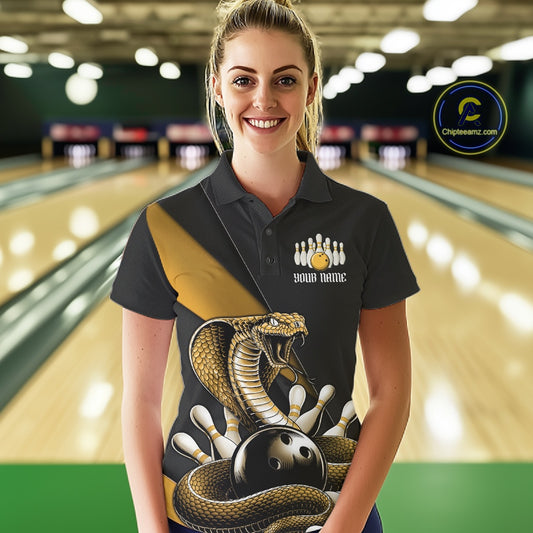 Female model at the bowling lane wearing a black bowling polo with yellow cobra artwork and bowling pins.