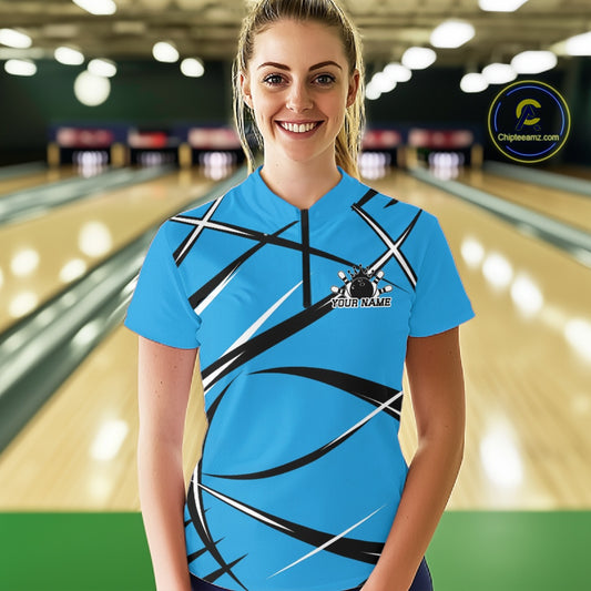 Front view of a female bowler wearing a blue, black, and white bowling quarter-zip shirt in a bowling lane