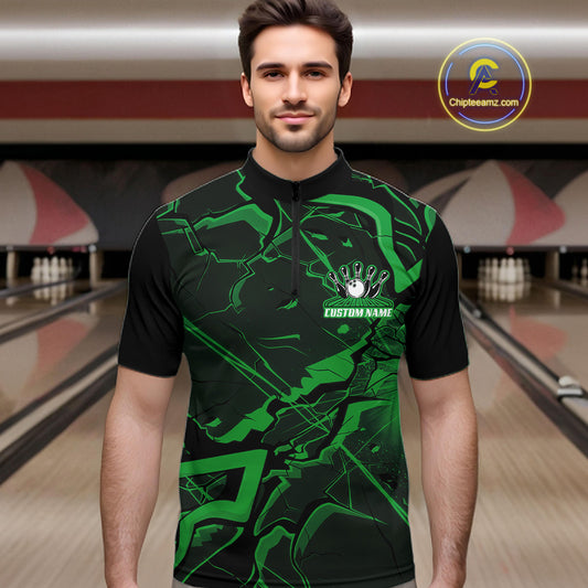 Male model wearing a black and green quarter-zip in a bowling lane with sharp cracked geometric artwork.