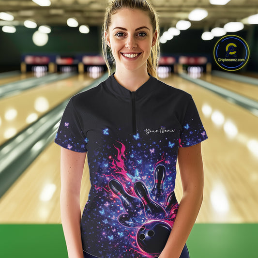 Female model wearing a colorful bowling quarter-zip shirt at the bowling lane with flames, pins, and butterfly graphics.