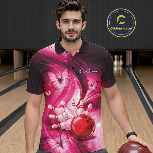 Male model in a bowling lane wearing a pink bowling polo with bowling strike graphics and butterfly artwork.