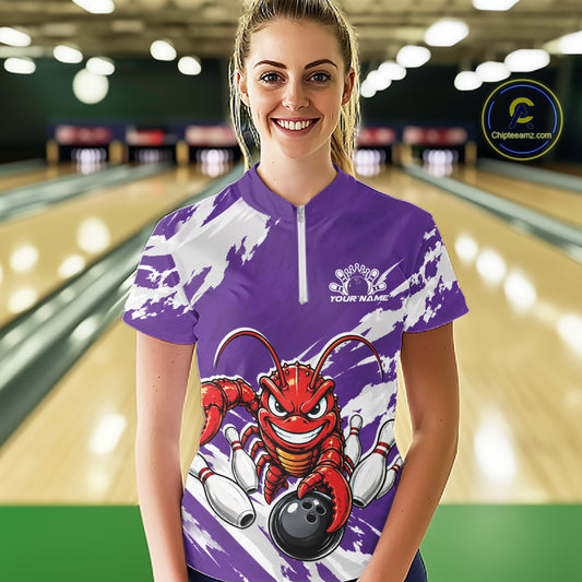 Front view of a happy female model in a bowling alley wearing a purple custom quarter zip bowling shirt with an aggressive crawfish bowling design and a distressed background.
