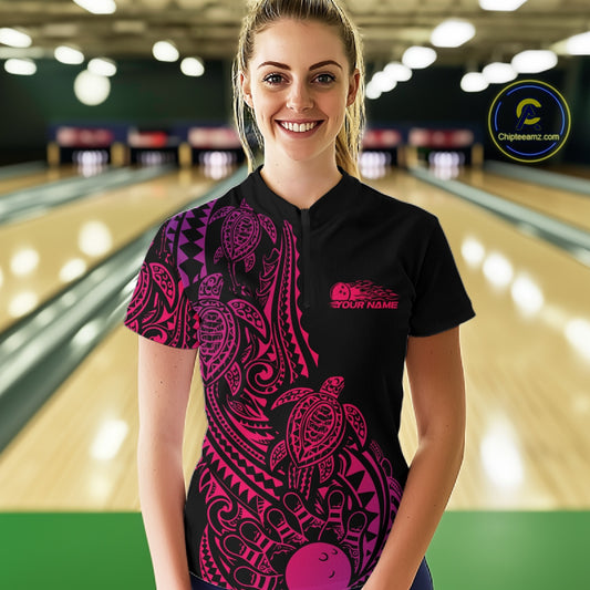 Female model wearing a black, pink, and purple bowling quarter-zip shirt at the bowling lane with tribal swirl bowling artwork and turtle motifs.