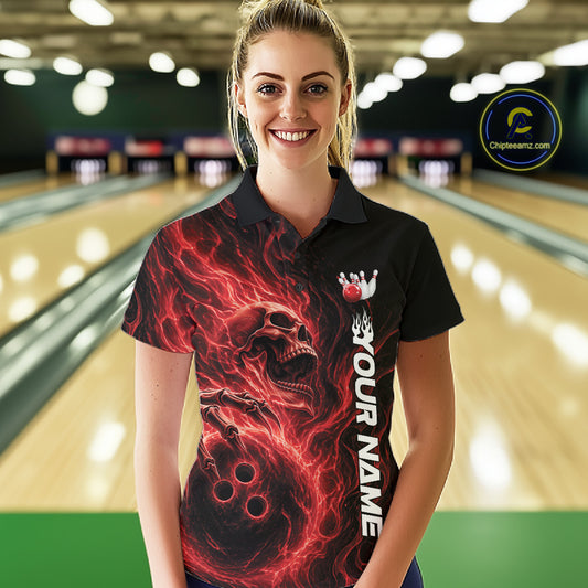 Female model wearing a black bowling polo shirt in a bowling alley featuring a skull clutching a bowling ball engulfed in swirling red energy flames
