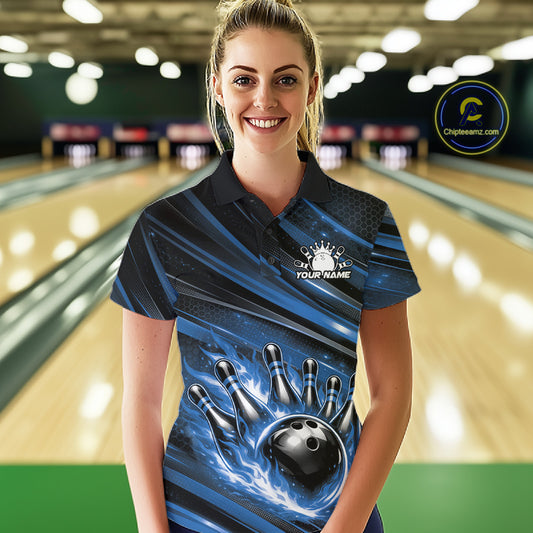 Female model wearing a black and blue bowling polo shirt at a bowling lane with fiery bowling action graphics and stripe details.