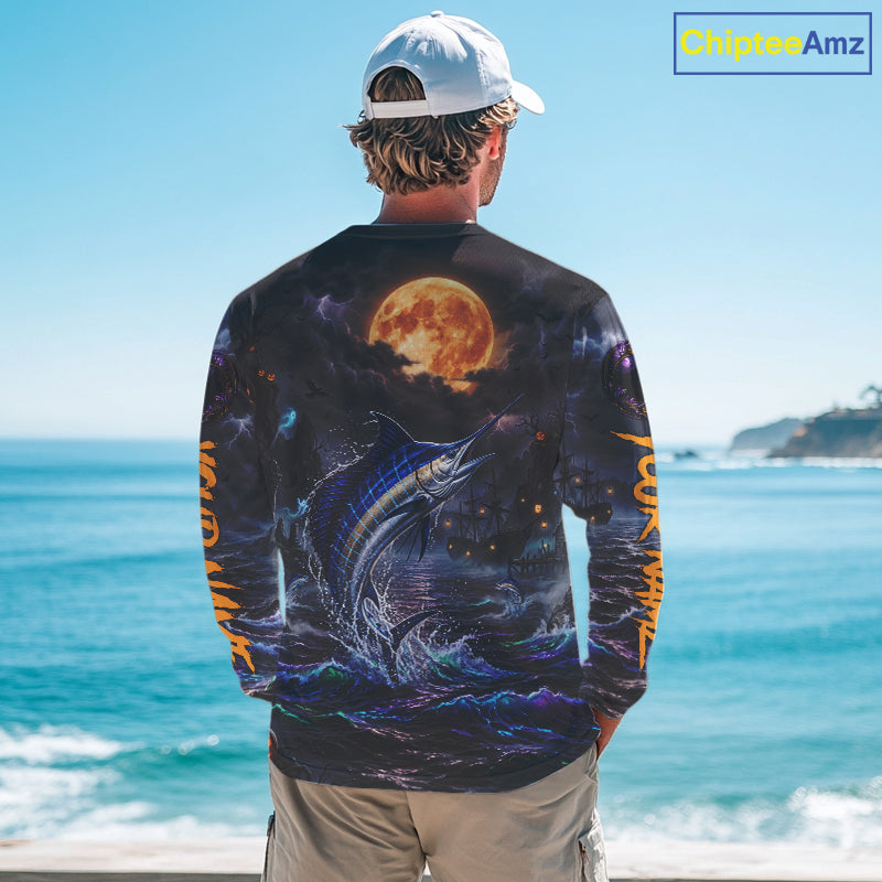 A man stands with his back to the camera wearing a long-sleeve graphic shirt featuring a large fish and a full moon under a starry night sky, with orange text down the sleeves, set against a beach background. A 'ChipteeAmz' logo is visible in the top right corner.
