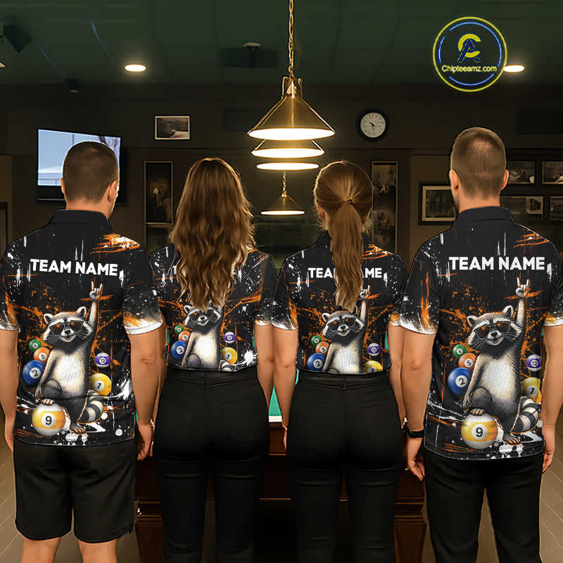 Four people wearing matching shirts with raccoon and pool ball designs in a room with a pool table.