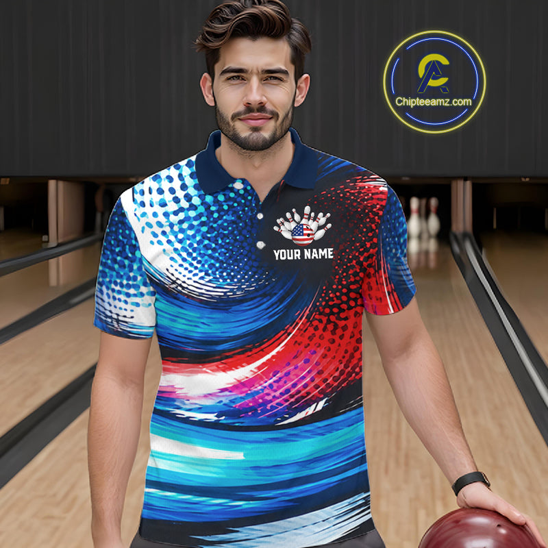 A man wearing a short-sleeve bowling polo shirt with a vibrant blue, red, and white abstract pattern, standing in a bowling alley. The shirt features a navy collar, a white crown graphic, and the text 'YOUR NAME'.
