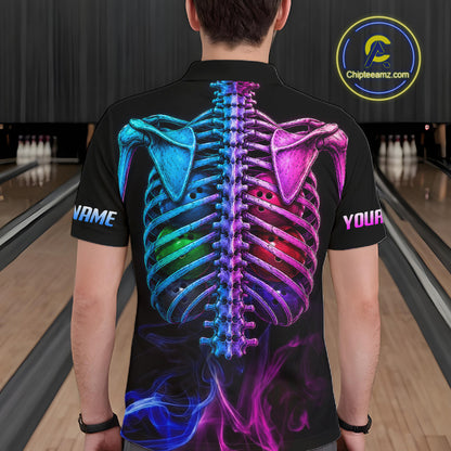 A man viewed from behind wearing a black short-sleeve polo shirt with a vivid glowing rib cage graphic in blue, purple, and pink on the back, plus customizable text placeholders on the sleeves. The background shows a bowling alley interior.