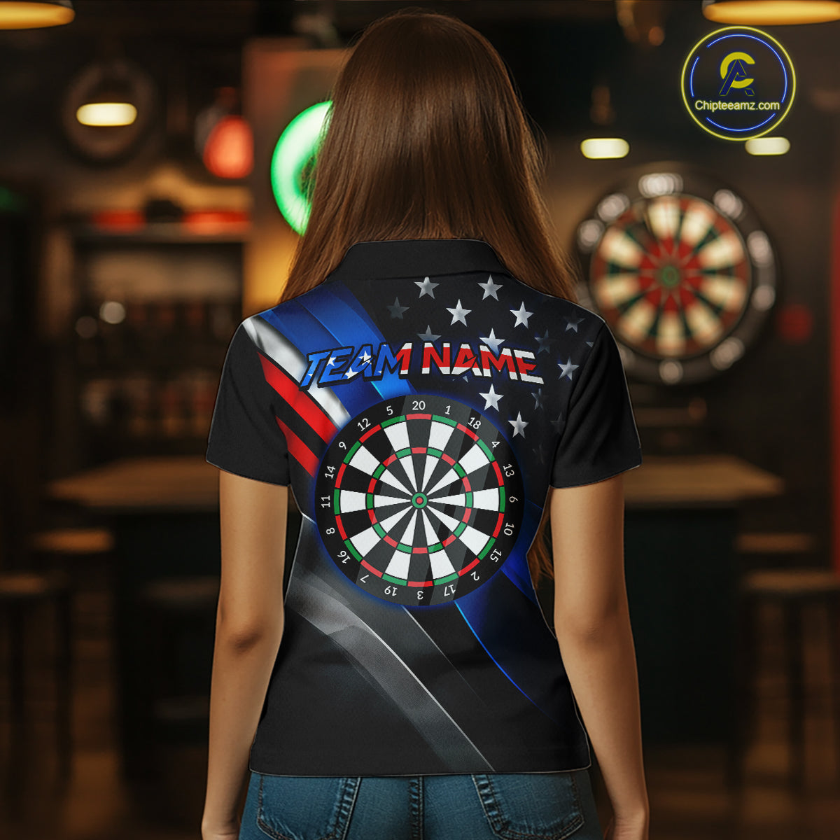 Back view of a man wearing a custom dart polo with personalized team name and a patriotic dartboard graphic with red, blue, and silver diagonal stripes in a professional dart room.