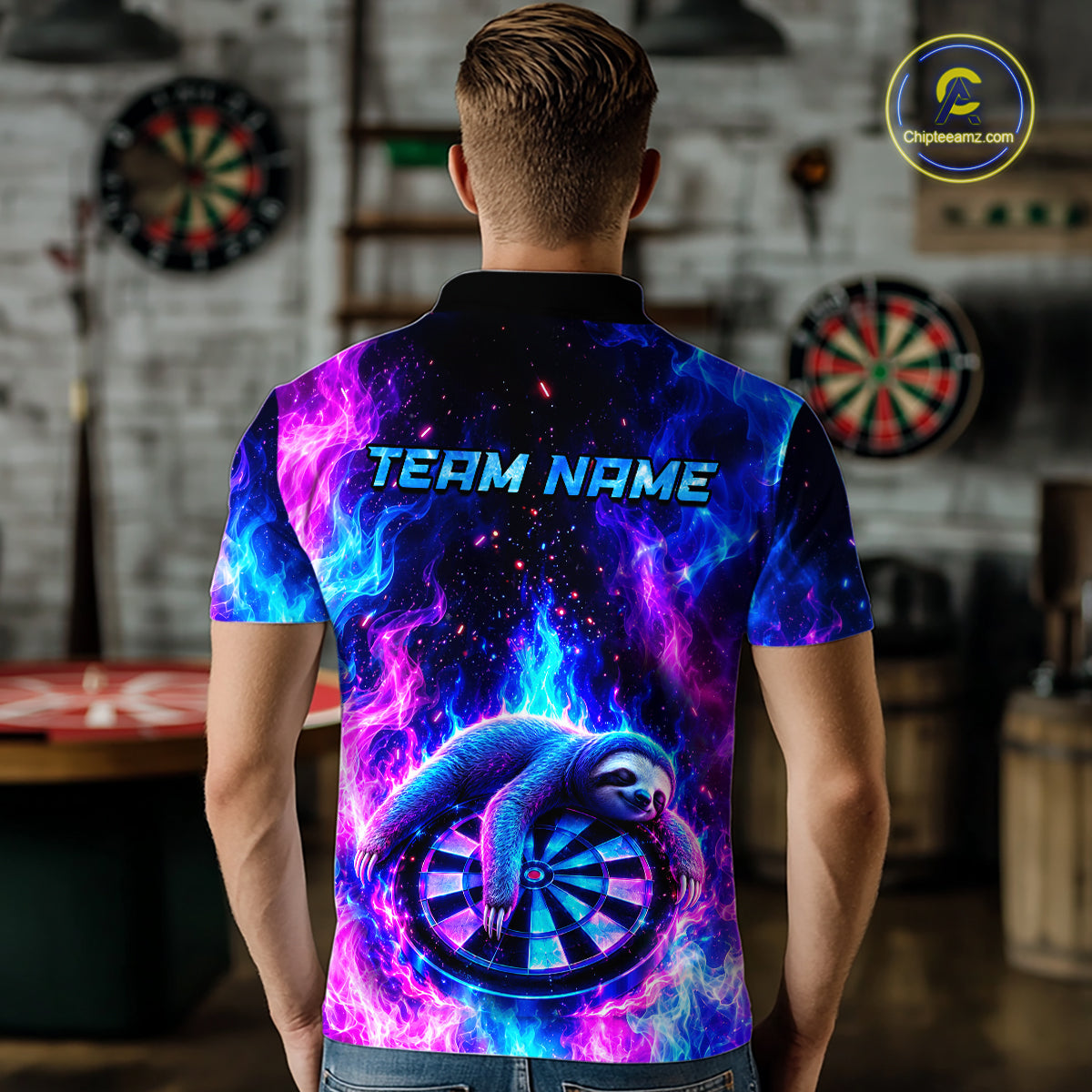 Back view of a man wearing a custom galaxy dart polo with personalized team name and a neon sloth holding a dartboard with glowing blue and purple cosmic artwork in a professional dart room.