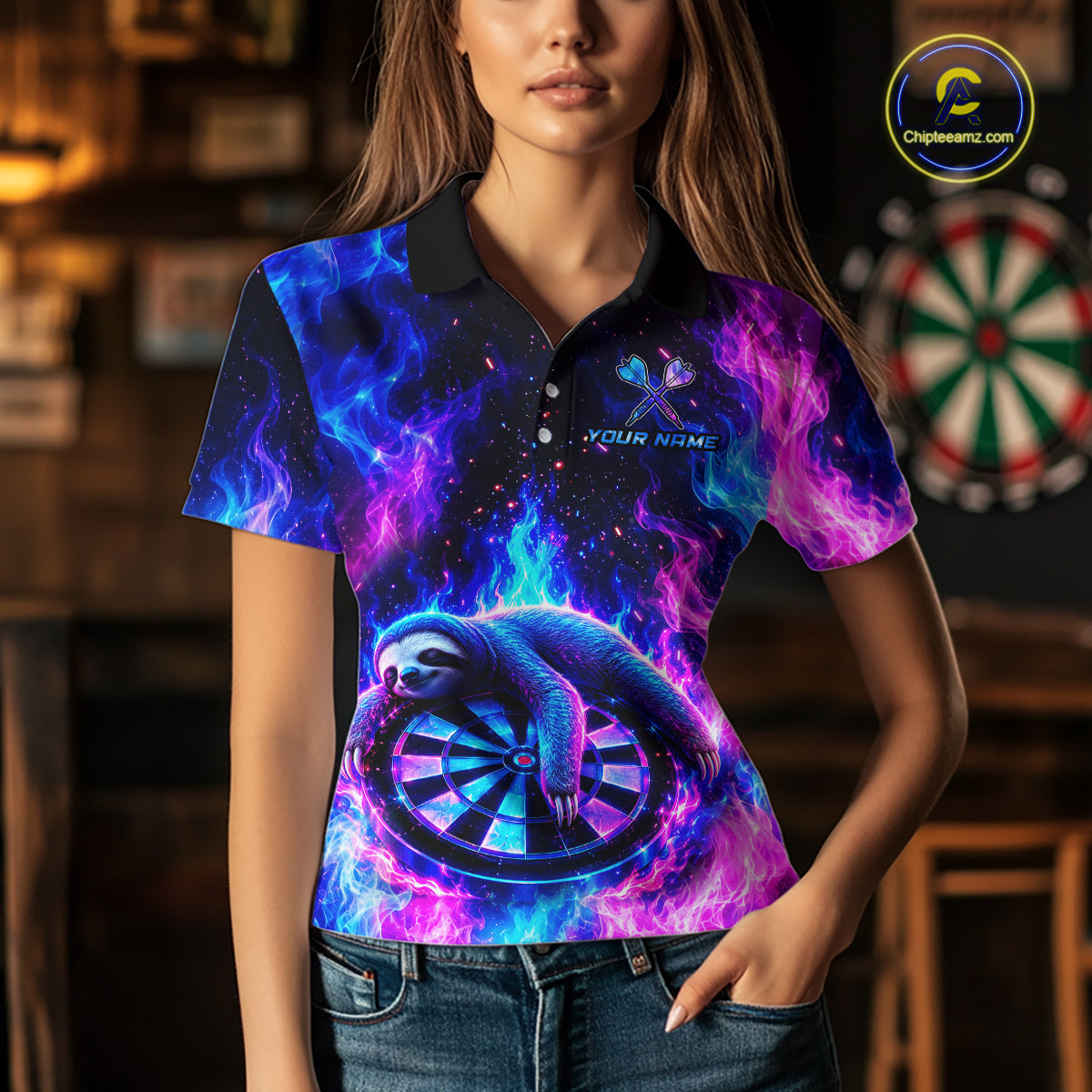 A woman wearing a short-sleeve polo shirt with a vibrant cosmic nebula print in blue, purple, and pink, featuring a sloth curled around a dartboard on the front. The shirt has a black collar and a custom graphic area that reads 'YOUR NAME'.