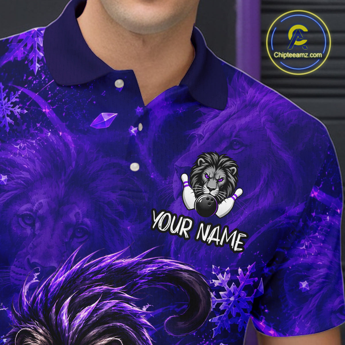 A close-up of a person wearing a short-sleeve polo shirt with a purple and blue graphic design featuring lion faces, bowling pins, snowflakes, and a customizable name patch reading 'YOUR NAME'.