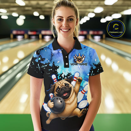 A woman stands in a bowling alley wearing a custom short-sleeve polo shirt with a cartoon pug bowling graphic and the text 'YOUR NAME'. The background shows blurred bowling lanes