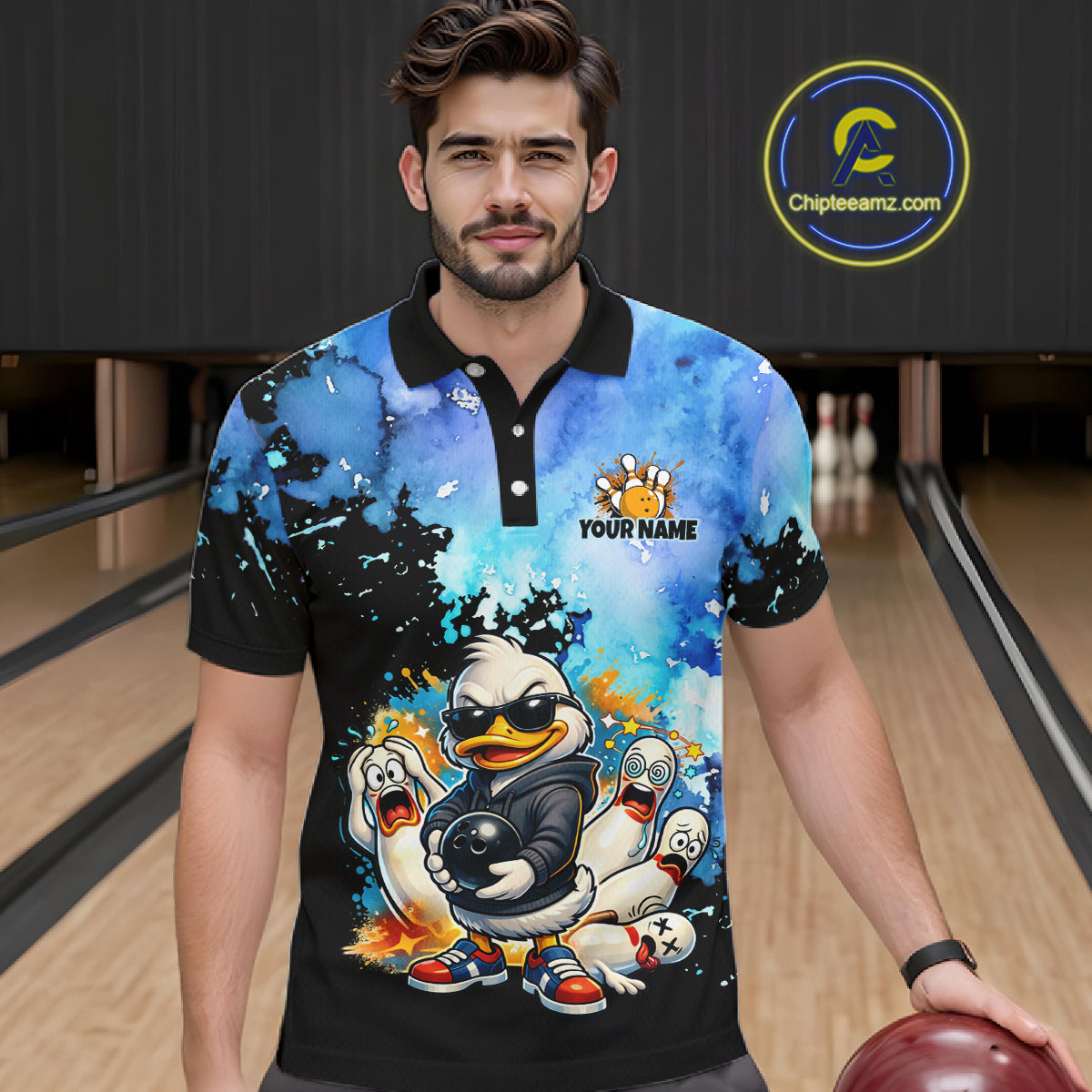 Man wearing a colorful polo shirt with a cartoon duck design in a bowling alley.