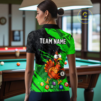 A woman stands in a poolroom wearing a custom-printed short-sleeve polo shirt. The back of the shirt features a black and bright green graphic design with the text 'TEAM NAME' and a cartoon turkey holding an 8-ball.