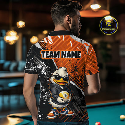 A man viewed from behind wearing a custom-printed short-sleeve polo shirt in a billiards/pool room. The shirt features a black and orange graphic design with a cartoon duck character holding a 9-ball and the text 'TEAM NAME'.