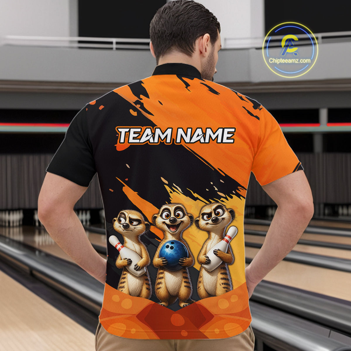 A man viewed from behind wearing a custom bowling-themed short-sleeve jersey. The jersey features a black and orange splatter design with the text 'TEAM NAME' and a graphic of three cartoon meerkats holding bowling pins and a blue bowling ball.