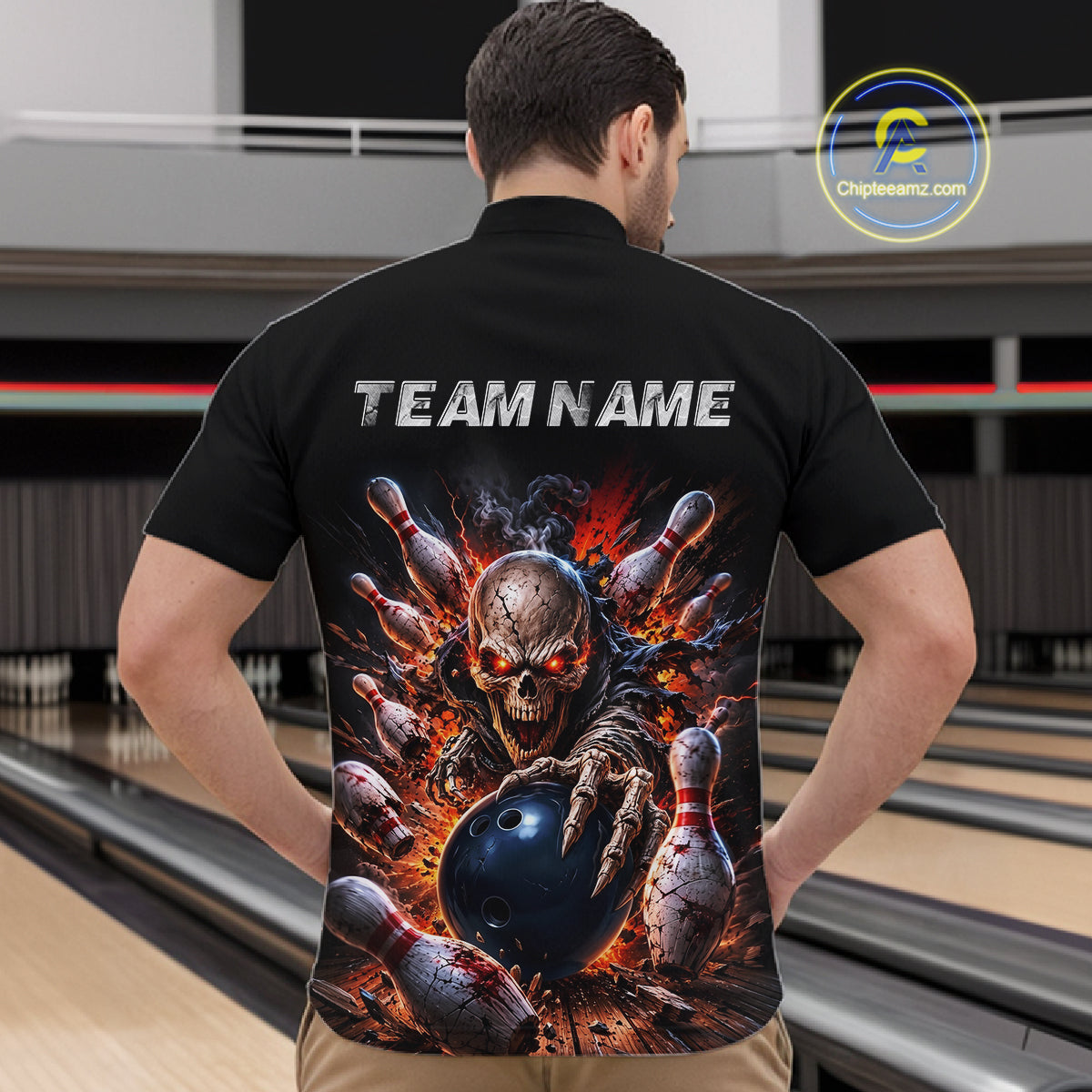 Person wearing a black quarter-zip jersey with a graphic design of a skeleton holding a bowling ball and pins, with 'TEAM NAME' text on the back, in a bowling alley.