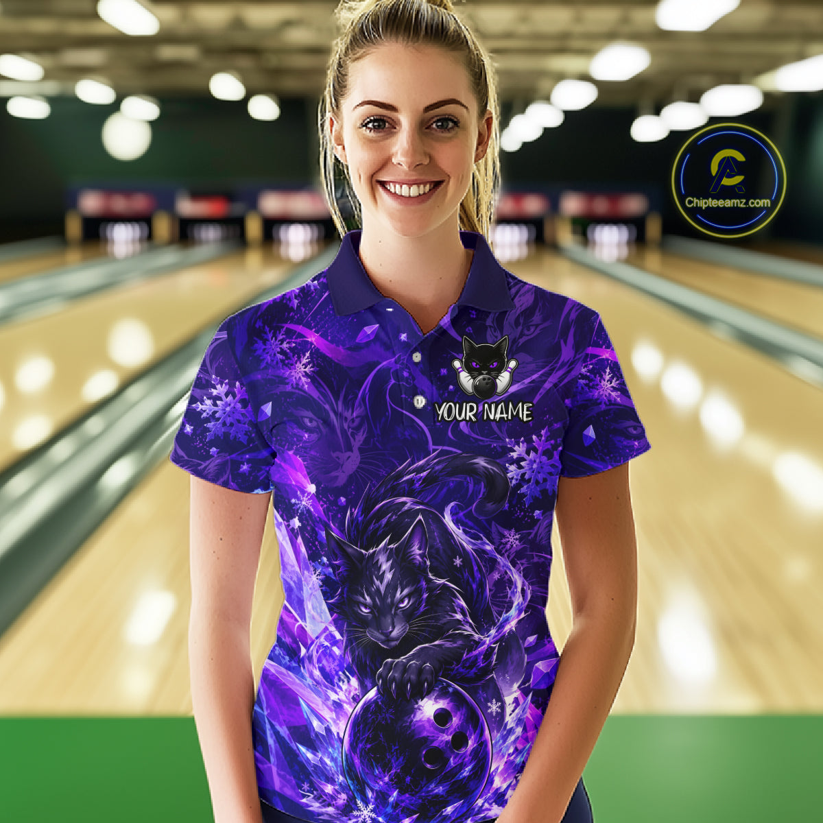 Woman wearing a purple bowling shirt with a cat design in a bowling alley.