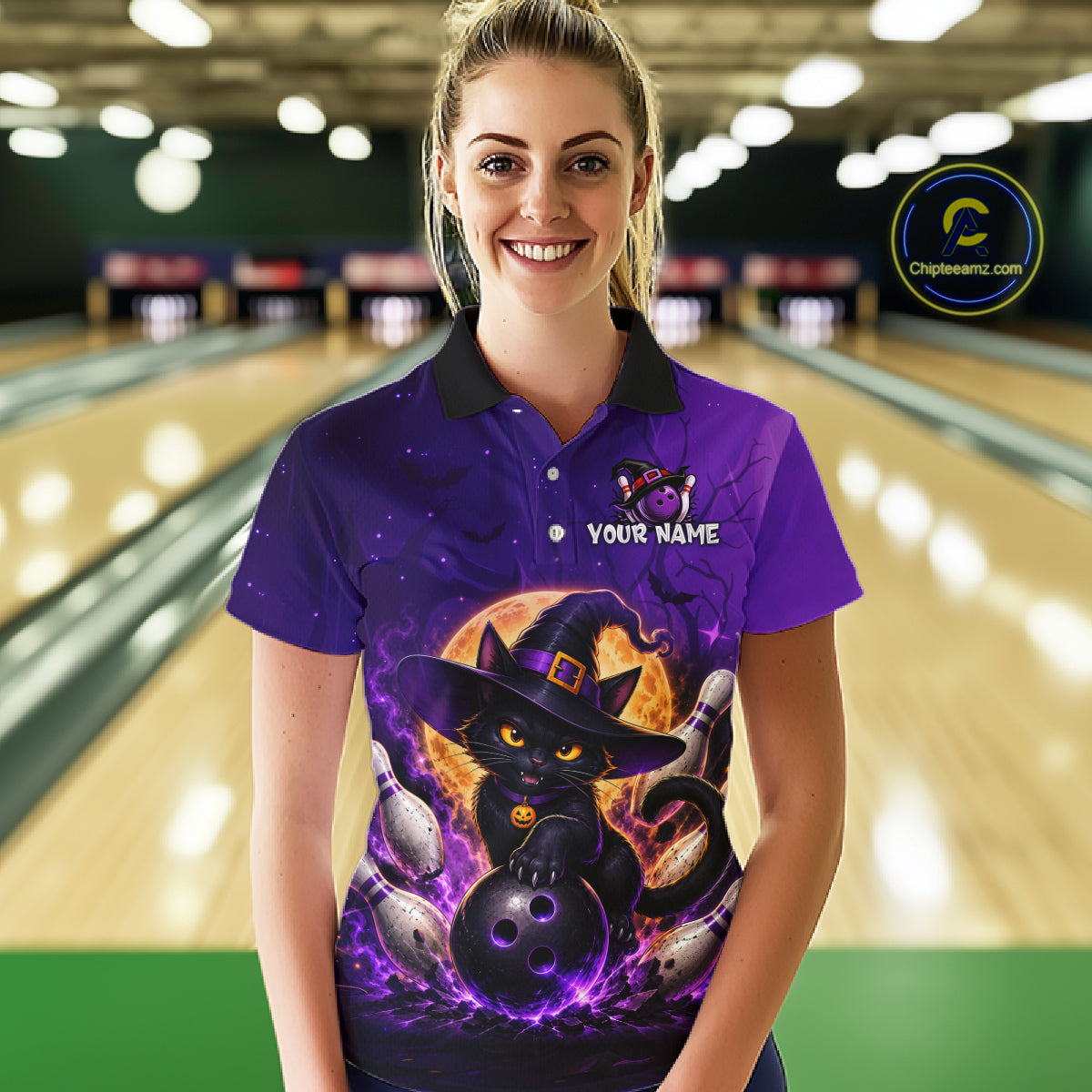 A woman wearing a purple short-sleeve polo shirt with a Halloween-themed graphic of a black cat in a witch hat holding a bowling ball, set against a blurred bowling alley background. The shirt features a black collar, a purple 'YOUR NAME' placeholder print on the chest