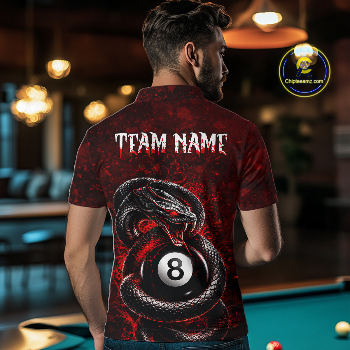 A man viewed from behind wearing a red and black short-sleeve polo shirt with a large snake wrapping around an 8-ball and the text 'TEAM NAME' on the back, standing in a dimly lit pool hall.