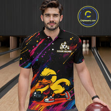 Load image into Gallery viewer, A man wearing a black short-sleeve bowling-themed polo shirt with a colorful paint splatter design and a cartoon duck graphic, standing in a bowling alley holding a bowling ball. A circular 'Chipleamz.