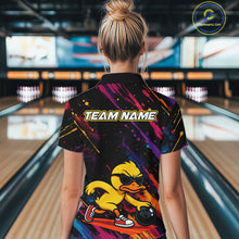 Load image into Gallery viewer, A woman viewed from behind wearing a short-sleeve bowling shirt with a colorful abstract print and a cartoon duck graphic on the back. The shirt has 'TEAM NAME' printed across the upper back, and the bowling alley lanes are visible in the background.