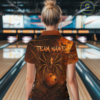 A woman viewed from behind wearing a short-sleeve bowling shirt with a large spider and bowling ball graphic on the back, standing in a bowling alley.