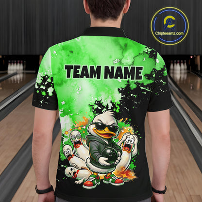 A person shown from the back wearing a short-sleeve collared shirt in a bowling alley. The shirt has a black base with a bright green splatter-style graphic, the text 'TEAM NAME' across the upper back, and a cartoon duck character holding a bowling ball near the lower back.