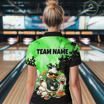A woman viewed from behind wearing a short-sleeve collared bowling-themed shirt in a bowling alley. The back of the shirt is bright green and black with the text 'TEAM NAME' and a cartoon duck-and-feather bowling graphic.