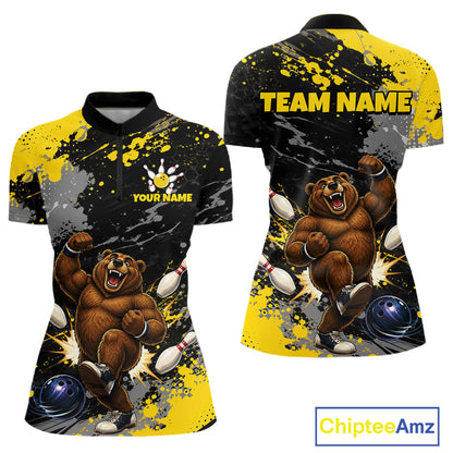 Front and back views of a women's short-sleeve polo shirt with a black, yellow, and gray paint-splatter design featuring a cartoon bear bowling theme. The front shows a black collar, a partial button placket, and customizable text 'YOUR NAME' with a bowling pin hand icon.