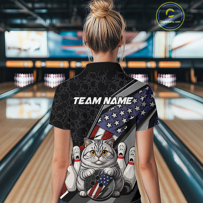 A woman viewed from behind wearing a black short-sleeve bowling-themed polo shirt with a large graphic print. The shirt features the text 'TEAM NAME', a gray cat holding a bowling ball with an American flag pattern, and bowling pins.