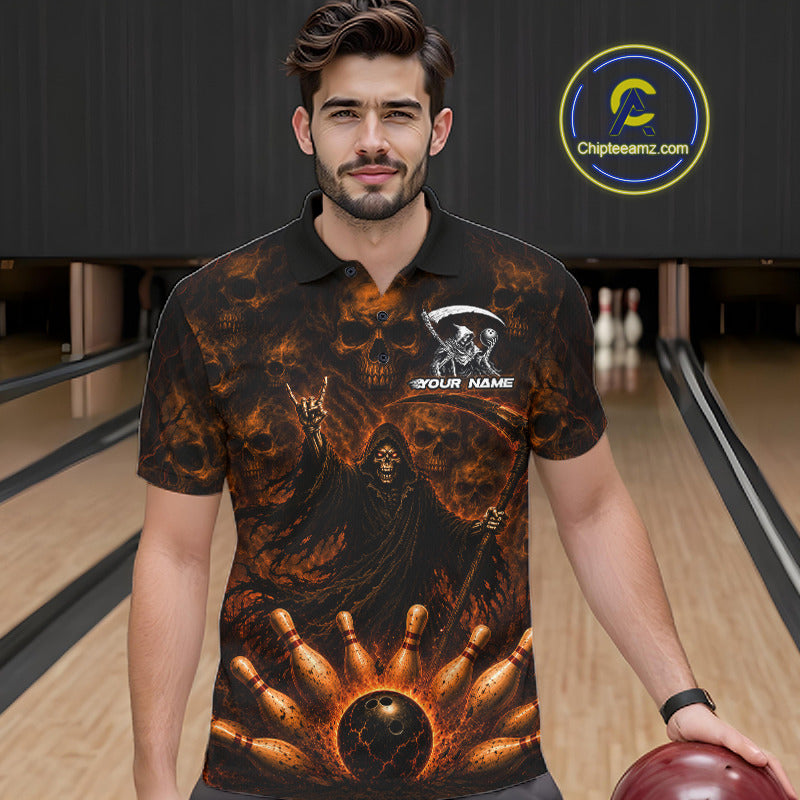 A man wearing a black short-sleeve polo shirt with a fiery orange and brown grim reaper graphic, standing in a bowling alley. The shirt features a skeleton figure, bowling pins, and a bowling ball design, with a customizable name placeholder on the chest.