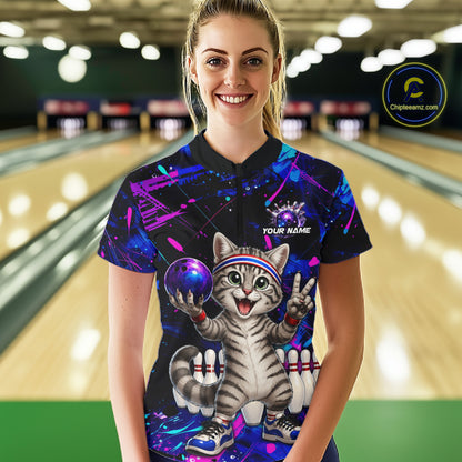 Person wearing a colorful bowling shirt with a cat design in a bowling alley.
