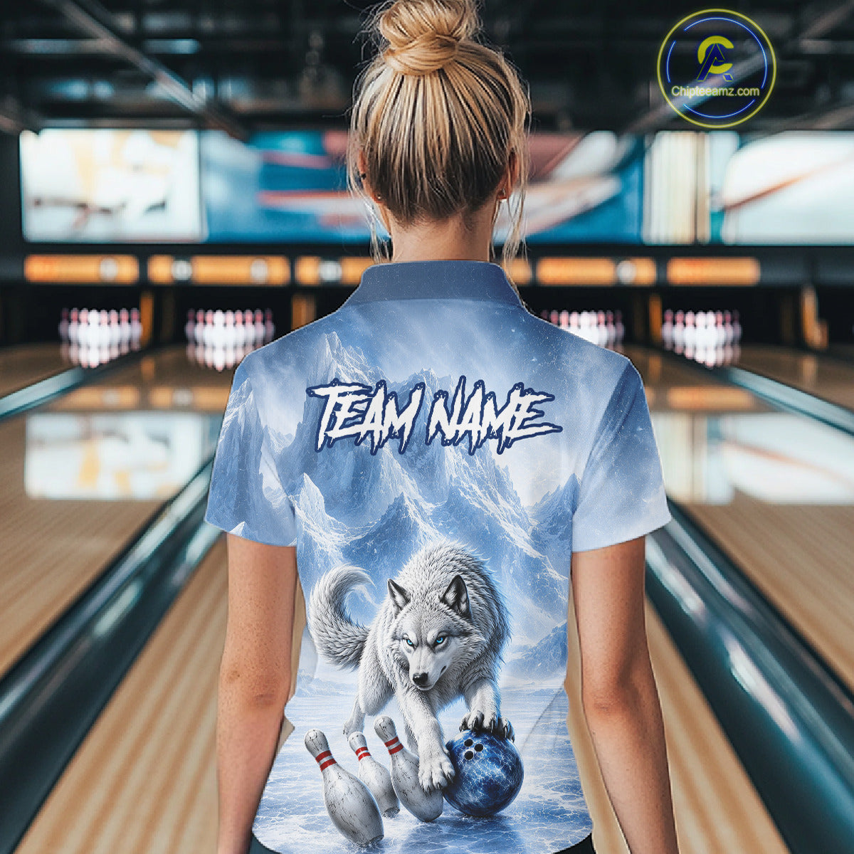 Person wearing a bowling shirt with a wolf design and 'TEAM NAME' text in a bowling alley.