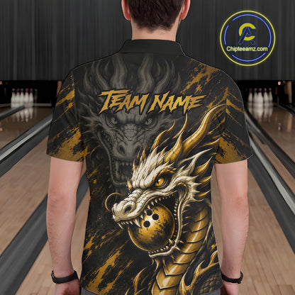 A man viewed from behind wearing a black short-sleeve button-up shirt with a large gold and gray dragon graphic and the text 'TEAM NAME' across the back. Bowling alley lanes are visible in the background