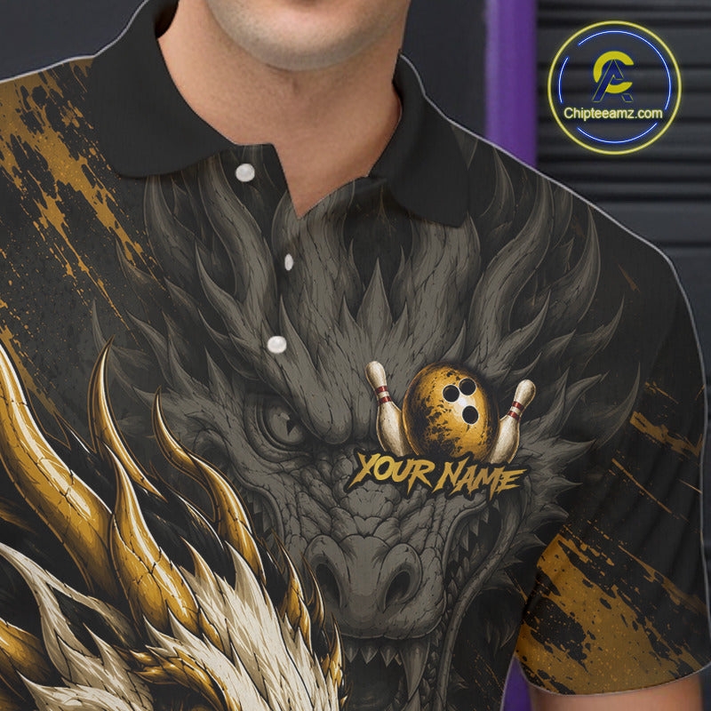 A close-up of a man wearing a short-sleeve polo shirt with a detailed graphic print of a dragon head and bowling pins. The shirt has a black collar and buttons, with a black, gray, and gold dragon design and the text 'YOUR NAME' printed on the chest.