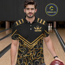 Load image into Gallery viewer, Male model wearing a custom black gold bowling polo shirt front view featuring a golden winged bowling ball emblem, geometric line pattern and premium black gold design at the bowling alley
