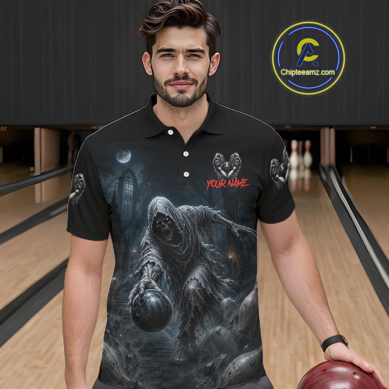 A man wearing a black short-sleeve polo shirt with a dark gothic graphic print of a hooded figure holding a bowling ball, standing in a bowling alley. The shirt features a red 'YOUR NAME' text customization placeholder on the chest.