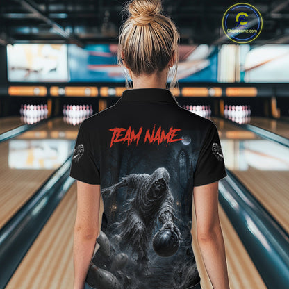 A woman viewed from behind wearing a black short-sleeve bowling shirt with a large horror-themed graphic print on the back and red 'TEAM NAME' text, standing in a bowling alley.