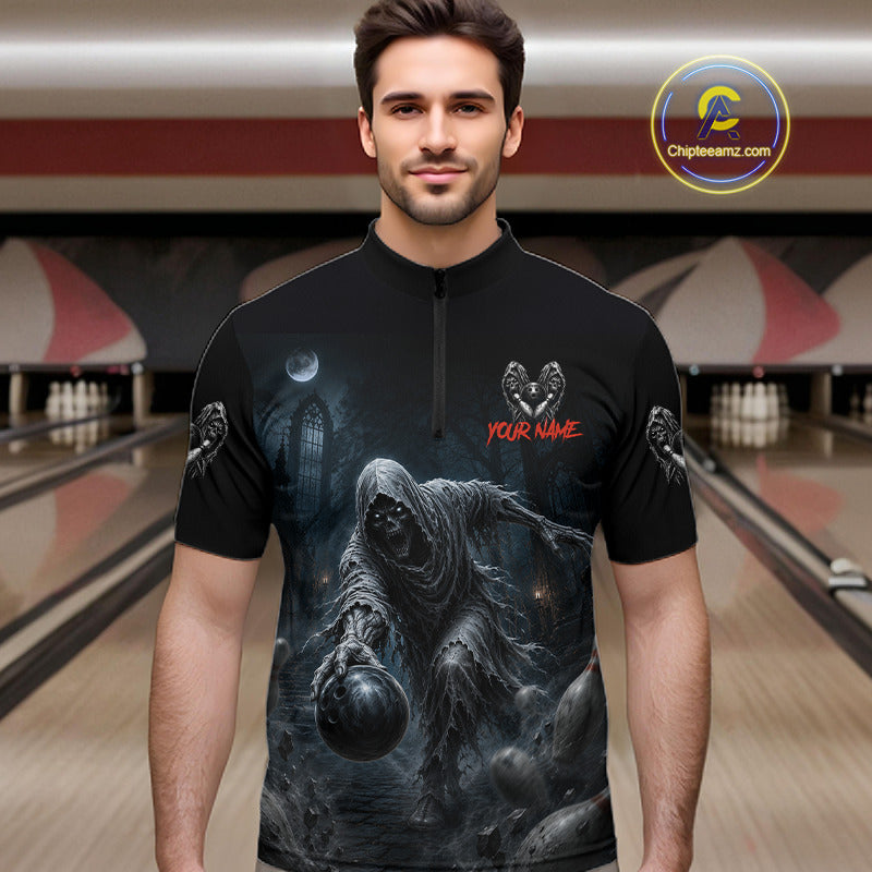A man wearing a black short-sleeve zip-front bowling shirt with a large dark gothic grim reaper graphic on the front, red 'YOUR NAME' text, and small winged skull motifs on the sleeves. Bowling alley lanes are visible in the background