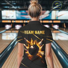 Load image into Gallery viewer, Woman wearing custom black gold bowling polo shirt back view featuring a fiery bowling ball and flame burst effect, displaying Team Name, at the bowling alley