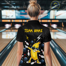 Load image into Gallery viewer, Person wearing a black bowling shirt with a banana character and 'Team Name' text in a bowling alley.