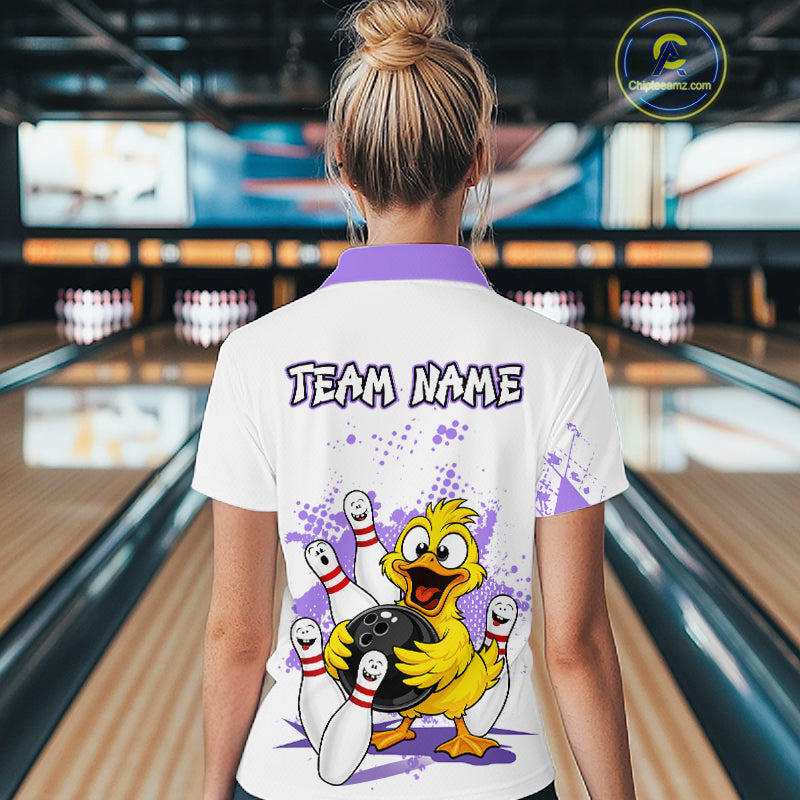A woman viewed from behind wearing a white bowling-themed polo shirt with a purple collar and a large cartoon duck graphic on the back. The shirt features the text 'TEAM NAME' and a bowling scene with pins, bowling balls, and purple splatter details.
