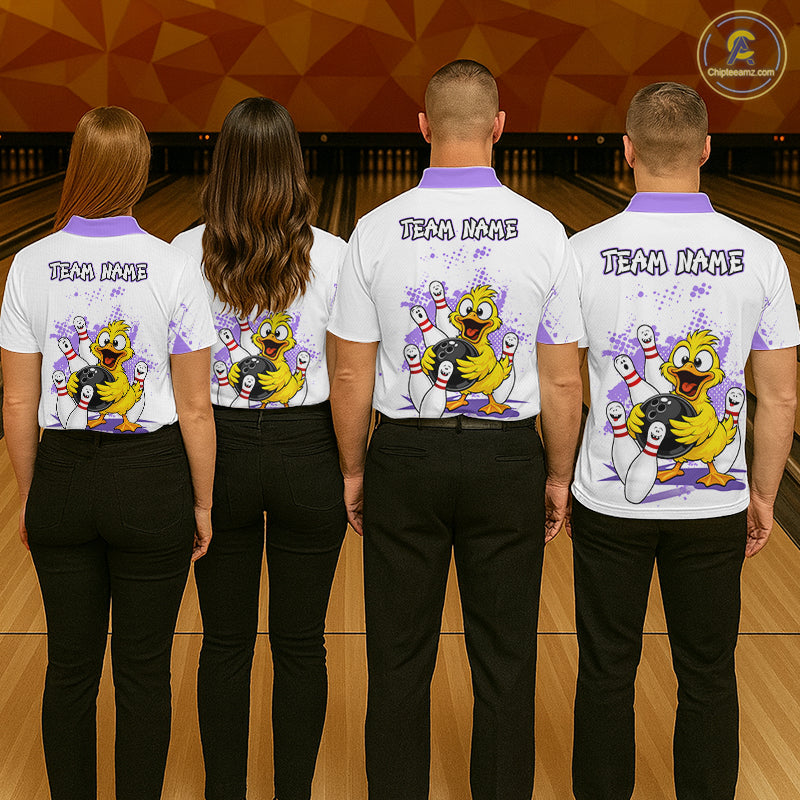 Four people standing from the back in a bowling alley, wearing matching white short-sleeve bowling shirts with purple collars and sleeves, black pants, and a large cartoon duck graphic on the back with the text 'TEAM NAME'.