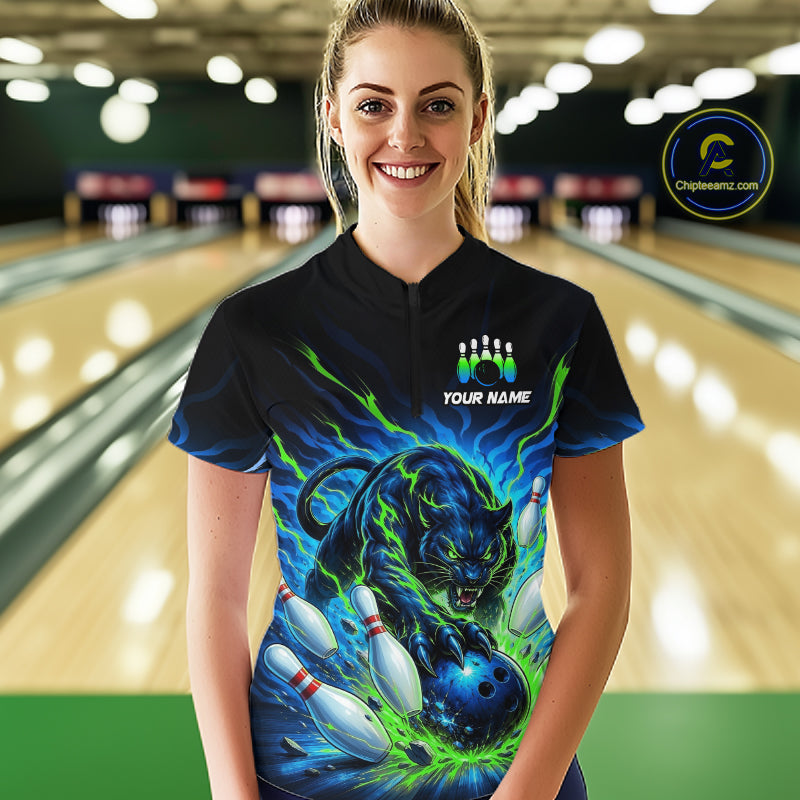 Person wearing a custom bowling shirt with a green and blue tiger design in a bowling alley.