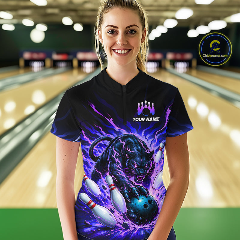 Person wearing a black t-shirt with a black panther design in a bowling alley.