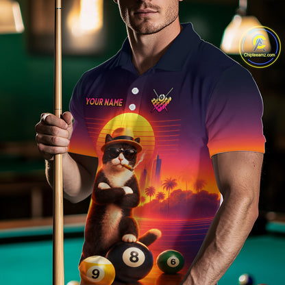 A man in a poolroom wearing a custom printed polo shirt with a graphic of a cat wearing sunglasses and a hat, sitting on pool balls against a sunset background. He is holding a pool cue.