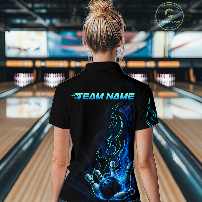A woman viewed from behind wearing a black short-sleeve polo shirt with a custom bowling-themed graphic. The shirt features 'TEAM NAME' printed in glowing blue text across the upper back, with a large blue and black flame-and-ball design on the lower back.
